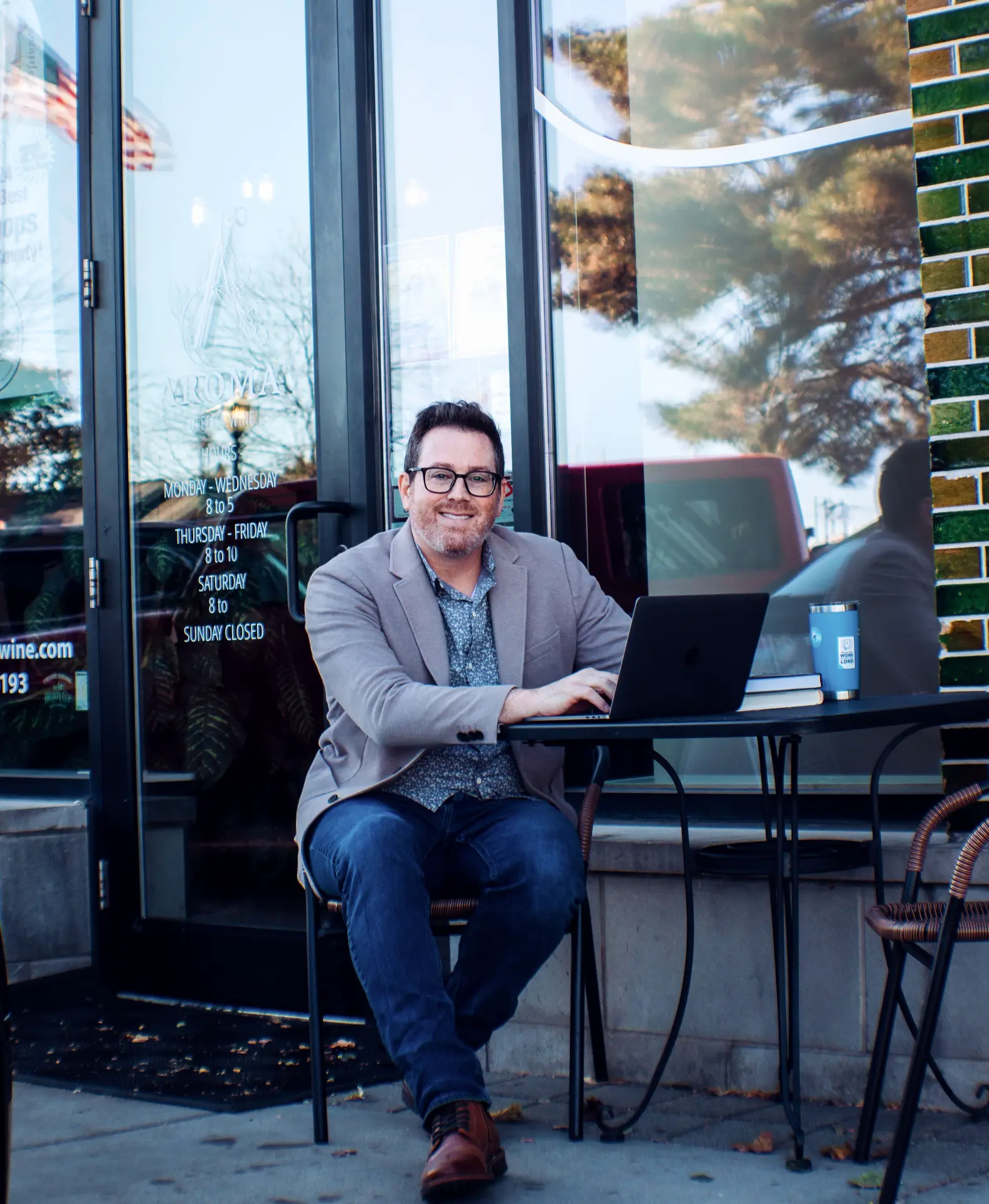 David Kearns, financial coach, working on a laptop outside a local coffee shop